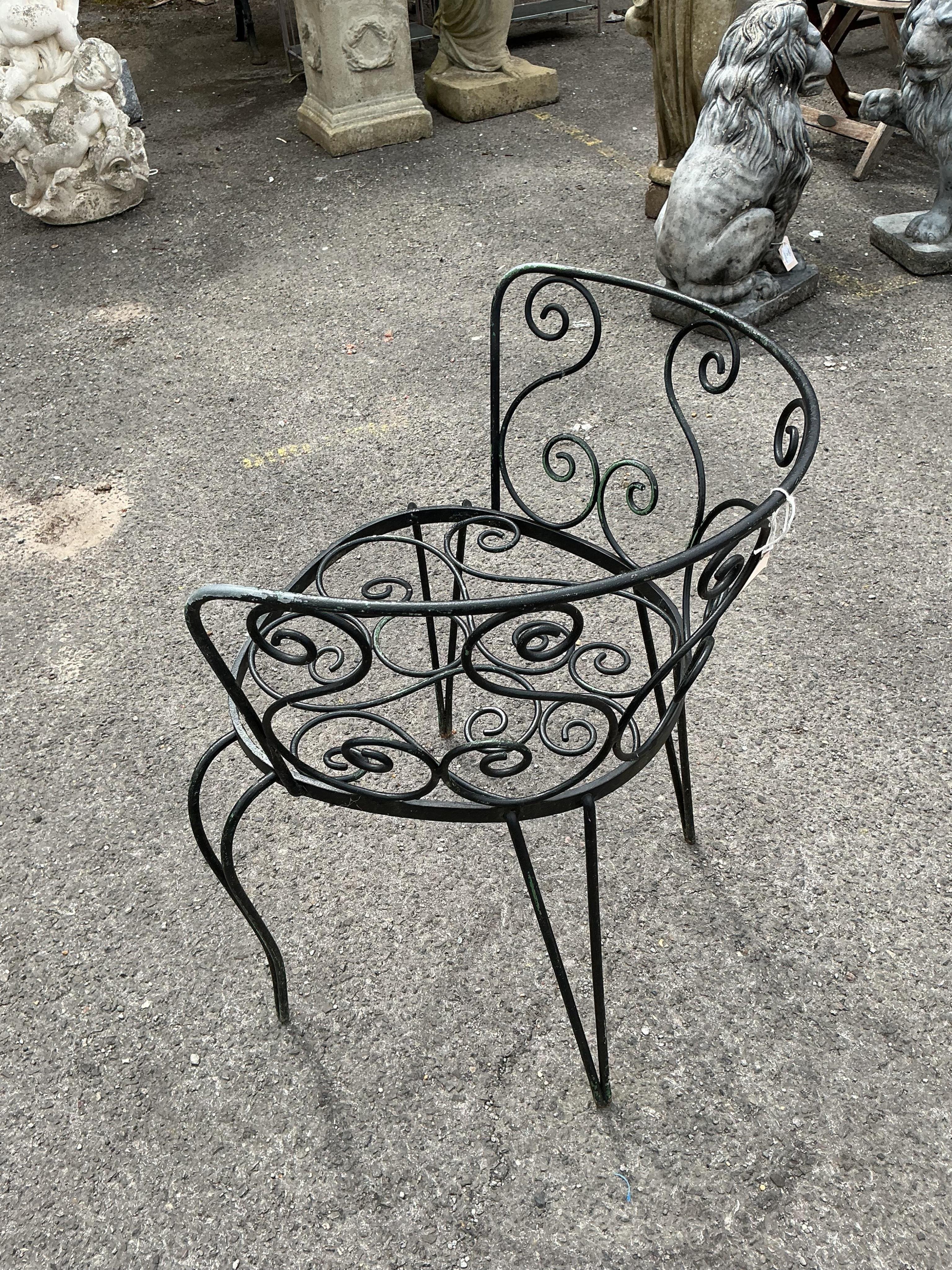 A circular stone mosaic topped garden table, diameter 80cm, height 72cm and six wrought iron garden chairs